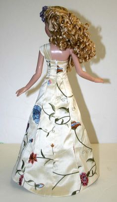 a doll with blonde hair wearing a white dress