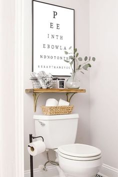 a white toilet sitting in a bathroom next to a shelf with an eye chart on it