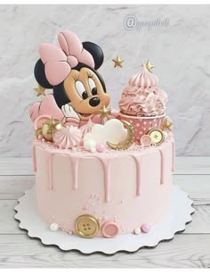 a pink cake with a minnie mouse on top