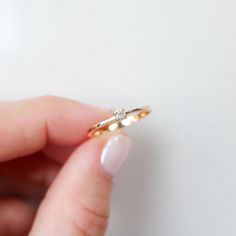 a person holding a diamond ring in their hand