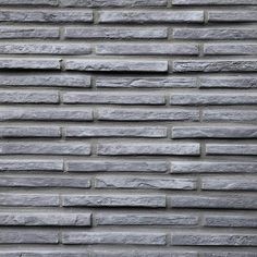 a brick wall that is made out of grey bricks