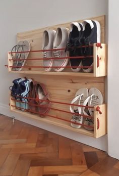 there are many pairs of shoes hanging on the wall in this shoe storage rack that is made out of wooden planks