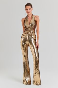 Tianna Gold Jumpsuit Women's Clothing > Jumpsuits. DESCRIPTION &  FEATURES  Feel a million dollars when dressed in the TIANNA Gold Jumpsuit,  a luxurious high-shine design. This halter neck jumpsuit is adorned with exclusively designed gold sequins and features fixed knot twist detailing to the front, forming elegant pleats to create a sculpting finish. This figure-hugging jumpsuit is finished with flared trousers, a concealed zip to the back, and is fully lined.   - Exclusively designed high-sh Gold Sequin Jumpsuit, Gold Jumpsuit, Sequin Pattern, Halter Neck Jumpsuit, Sequin Halter, Flare Jumpsuit, Sequin Jumpsuit, Bodycon Jumpsuit, Halter Jumpsuit