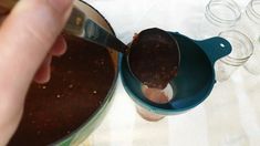 a person scooping food out of a blue bowl with a spoon in it on a table