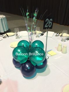 balloons are arranged in the shape of flowers on a round table with white linens