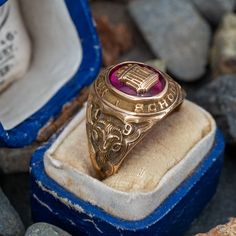 This attractive Kearny High School 1949 class ring is centered with an oval cabochon cut lab created ruby gemstone. The ruby is then centered with a gold appliqué. The shoulders of the ring are decorated with rams and great etchings. The ring is crafted of 10k yellow gold with a nice unpolished patina. Classic Oval Cabochon Collectible Jewelry, Classic Ruby Ring With Polished Finish For Collectors, Formal Oval Cabochon Ruby Ring With Polished Finish, Formal Ruby Signet Ring, Classic Domed Collectible Jewelry, Antique Oval Collectible Rings, Ceremonial Oval Cabochon Rings, Formal Ruby Signet Ring In Fine Jewelry Style, Fine Jewelry Ruby Signet Ring For Formal Occasions