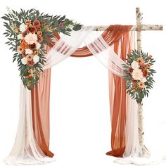 an orange and white wedding arch with sheer drapes, flowers and greenery on it