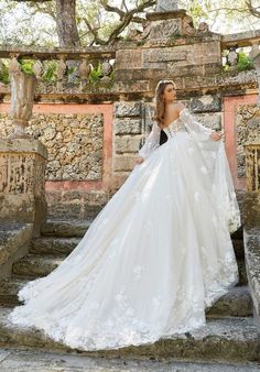 a woman in a wedding dress standing on some steps