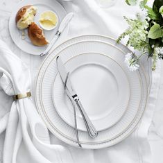 a table set with plates, silverware and flowers