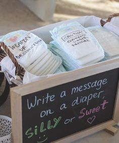 several diapers are in a basket on the floor next to a sign that says write a message on a diaper, silly or sweet