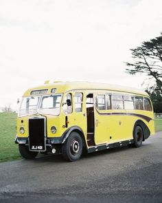 an old yellow bus is parked on the side of the road