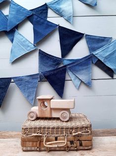 a wooden toy truck sitting on top of a wicker basket next to a wall