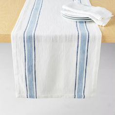 a table with a white and blue striped cloth on it next to a wooden table