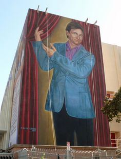 a large mural on the side of a building with a man in a blue suit