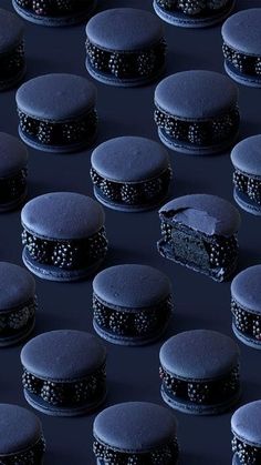 rows of black cakes with frosting on them