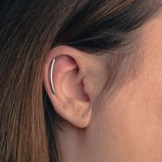 a woman's ear is shown with a thin nose ring in the shape of a circle