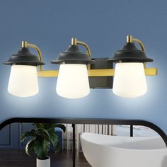 three light bathroom vanity fixture with white glass shades and gold accents in a blue room