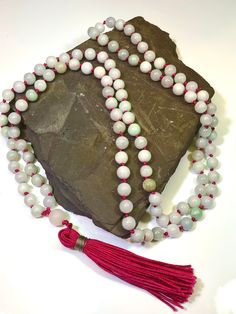 108 beaded natural Jadeite Mala Necklace  Gems: 506ct Jadeite 8mm plain round gemstones and 10.3 Rose Quartz Guru bead Length 24" inches  A Mala Necklace Mala Beads are more than just pretty necklaces. Each element of a Mala Necklace carries a meaning. Learn more about each part of a Mala Necklace and how it can help you on your own journey of meditation and intention setting. 108 Beads Malas always have 108 Beads. According to traditional Buddhism, 108 represents the number of mortal desires of Spiritual Jade Jewelry With 108 Beads, Spiritual Hand-strung Jade Beaded Necklace, Spiritual Single Strand Jade Beaded Necklace, Gemstone Beads Mala As Gift, Spiritual Round Jade Beaded Necklaces, Spiritual Round Jade Beaded Necklace, Spiritual Jade Beaded Necklace, Round Gemstone Beads Mala As Gift, Hand-strung Jade Beaded Necklaces With Round Beads