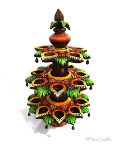 a colorfully decorated christmas tree made out of ceramic pots and candles on a white background