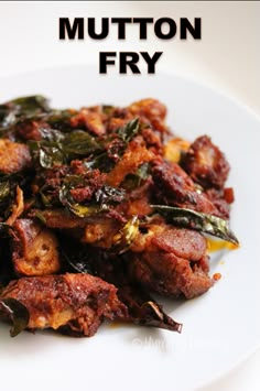 a white plate topped with meat and greens on top of a wooden table next to the words mutton fry