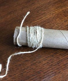 a roll of twine sitting on top of a wooden table