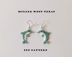 a pair of beaded earrings with the word miller west texas written in white letters