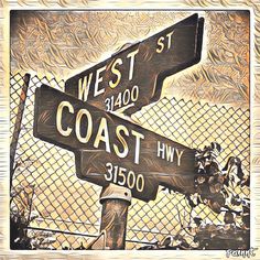 two wooden street signs sitting on top of a metal fence