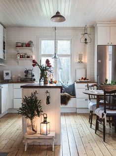 a kitchen filled with lots of furniture and decor on top of hard wood flooring