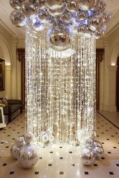 a large chandelier with silver balls hanging from it's sides in a lobby