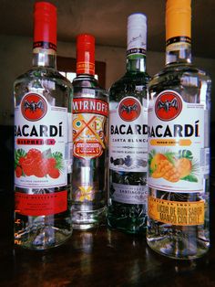 three bottles of alcohol sitting on top of a wooden table