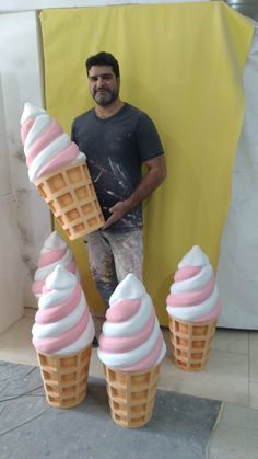 a man standing next to three ice cream cones