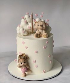 a white cake with pink hearts and teddy bears on top