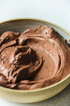 a bowl filled with chocolate frosting on top of a table