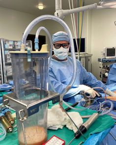 two doctors in scrubs and masks operating on equipment