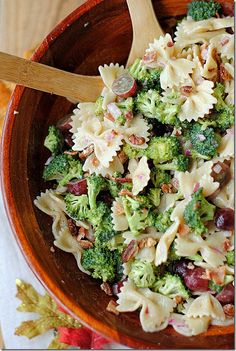 a wooden bowl filled with pasta and broccoli