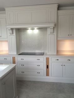 an empty kitchen with white cabinets and counter tops