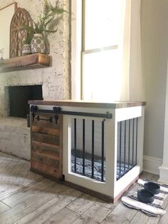 a dog crate sitting on the floor in front of a fireplace