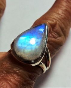 Vintage rainbow moonstone ring with bright aqua blue to deep cobalt blue flash in a solid sterling silver ringThe spectacular colors in this gem range from pale aqua to peacock blue to deep cobalt blue throughout the gorgeous pear moonstone.The pearl rainbow moonstone ring is a size 7.  The ring is well crafted of solid sterling silver, and has an open back so the lovely moonstone energy can be felt on your finger.This vintage ring was stored carefully, and has been cleaned and polished.  It is Unique Opal Ring With Moonstone, Mystical Moonstone Jewelry With Large Stone, Teardrop Moonstone Gemstone Ring, Mystical Cabochon Ring For Anniversary, Mystical Cabochon Jewelry For Anniversary, Mystical Anniversary Ring With Cabochon, Fusion Style Moonstone Gemstone Jewelry, Moonstone Jewelry With Large Round Stone, Fusion Style Oval Moonstone Ring For Anniversary