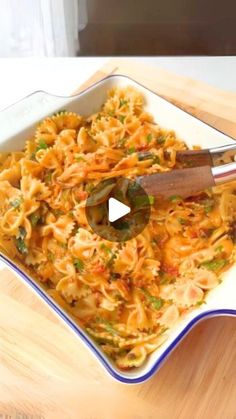 a bowl filled with pasta and sauce on top of a wooden table