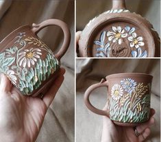 a hand holding a coffee cup with flowers painted on it's side and the bottom