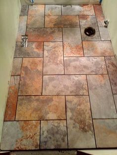 a bathroom with a toilet and tiled flooring in it's shower stall area