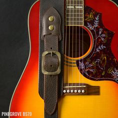 the guitar strap is attached to an acoustic guitar