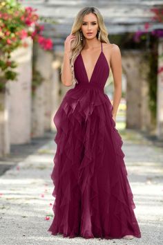 A woman wears a deep burgundy, floor-length dress with layered ruffles, standing confidently in a floral courtyard with soft lighting and greenery in the background, suggesting a romantic setting. Summer Tulle Maxi Dress With V-neck, V-neck Tulle Maxi Dress For Prom, V-neck Tulle Maxi Dress For Gala, Tulle V-neck Maxi Dress For Gala, Mulberry Dress, Bachelorette Party Dress, Dress Lining, Cross Dress, Rehearsal Dinner Dresses