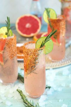 three glasses filled with different types of drinks and garnished with herbs, limes, and grapefruit