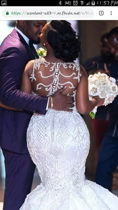 the bride and groom are embracing each other in their wedding dress, which is decorated with white flowers