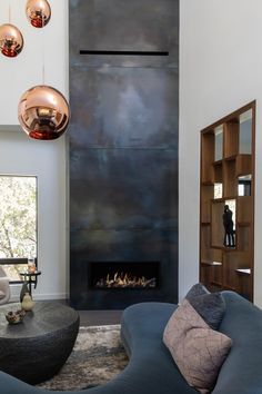 a modern living room with a fireplace and two chairs in front of the fire place