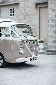 an old vw bus with a bride and groom in the back seat is parked outside