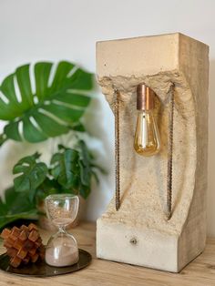 a lamp that is on top of a table next to a vase and some rocks