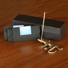 a gold figurine sitting on top of a wooden table next to a black box