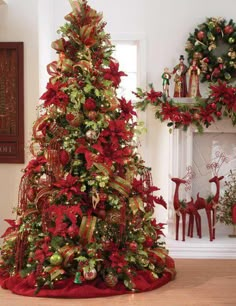 a christmas tree decorated with red and gold ribbons, poinsettis and wreaths